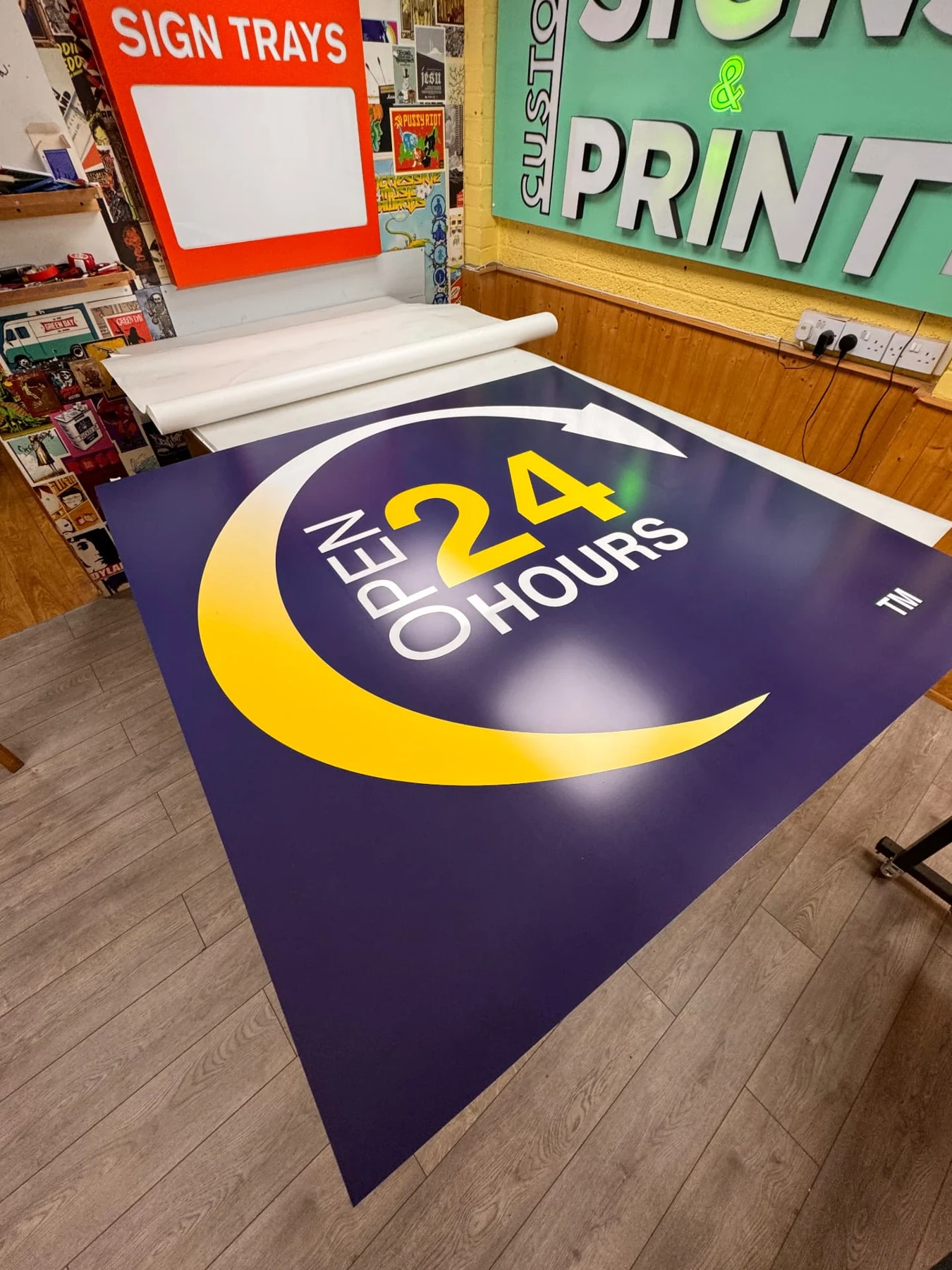 Replacement Open 24 Hours sign panel with a yellow crescent on a workshop bench