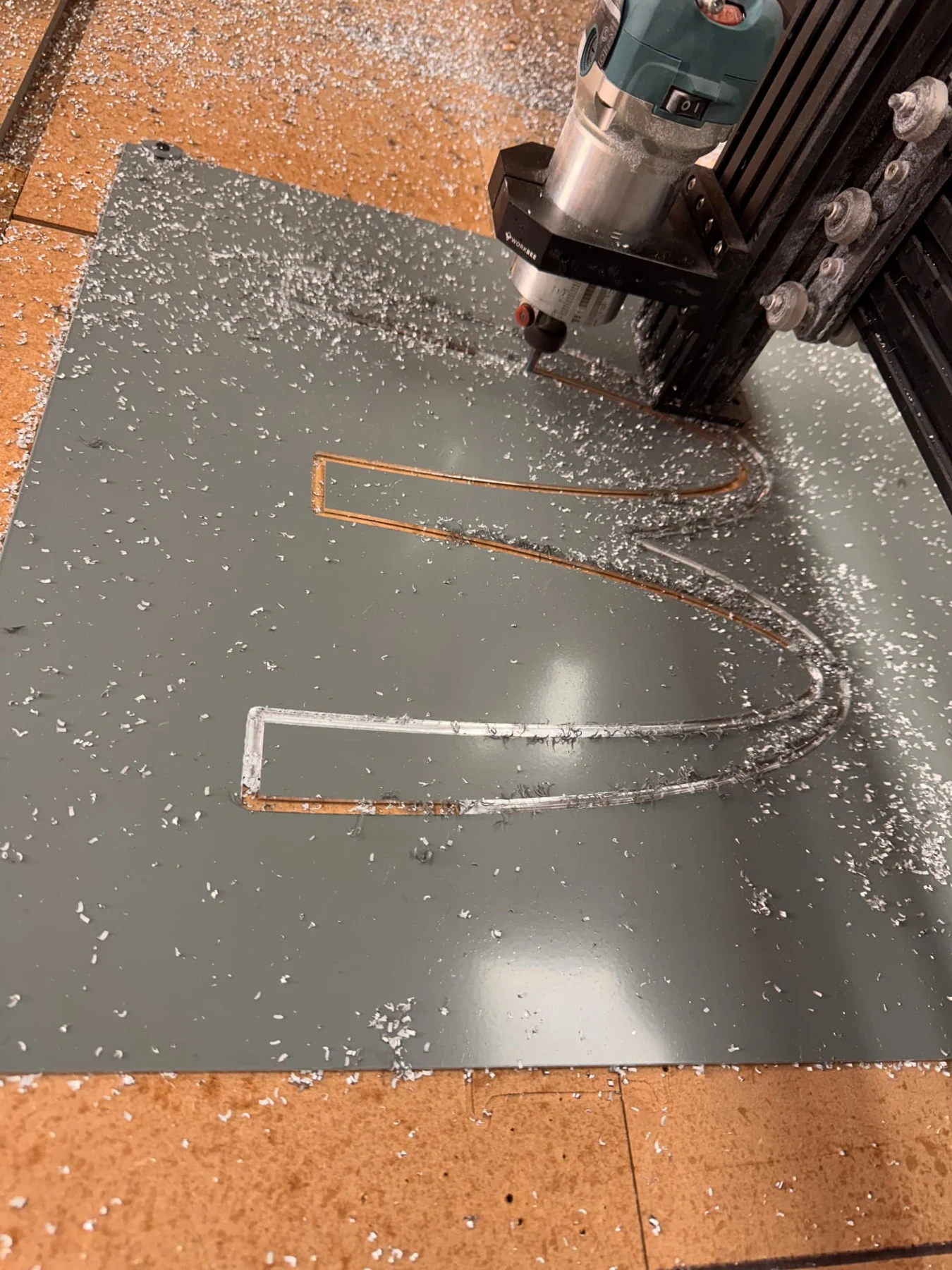 CNC router cutting lettering apertures into a solid aluminium panel