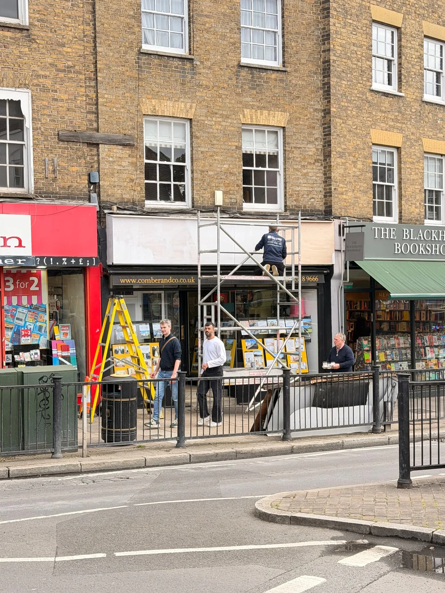 Work in progress at Comber & Co: installer working from scaffolding on the replacement wooden fascia