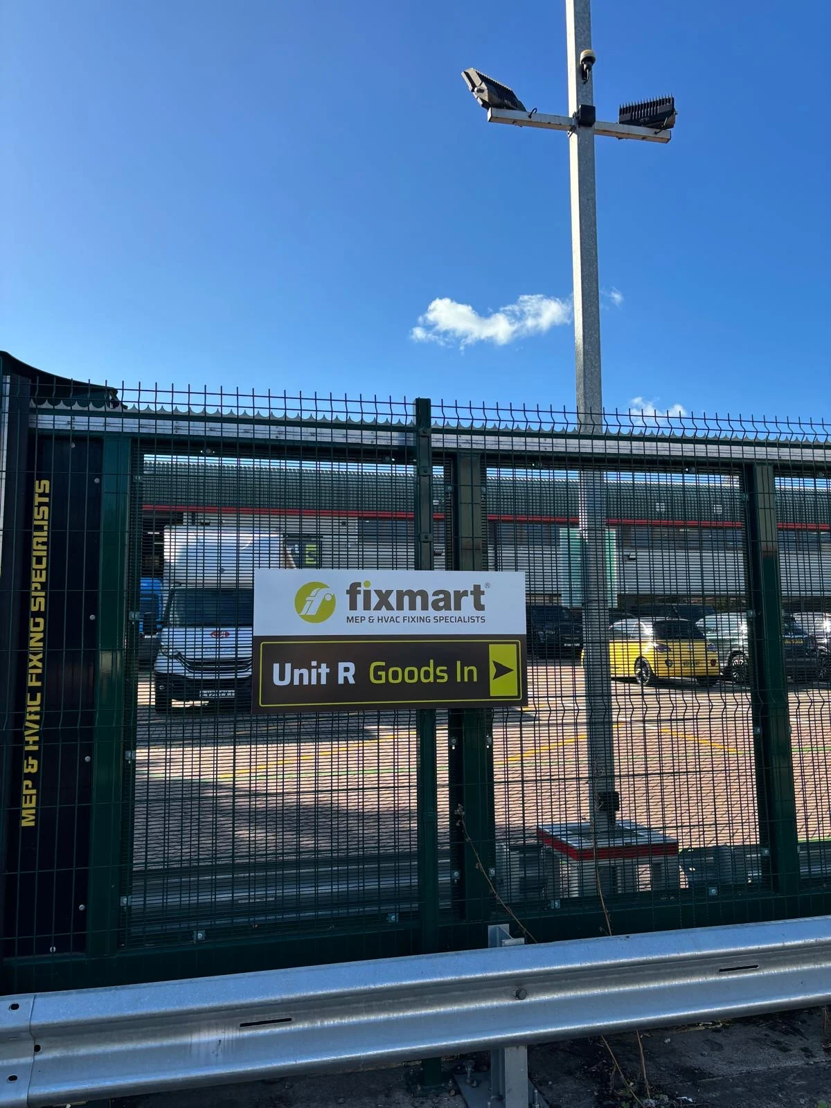Fixmart Unit R goods-in directional sign fixed to a metal gate