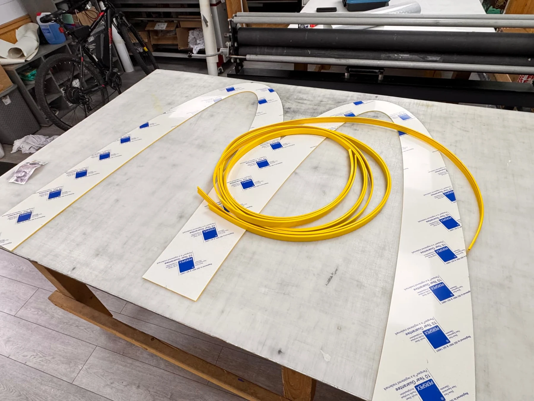 Cut acrylic arches with protective masking and coiled yellow edging material before assembly