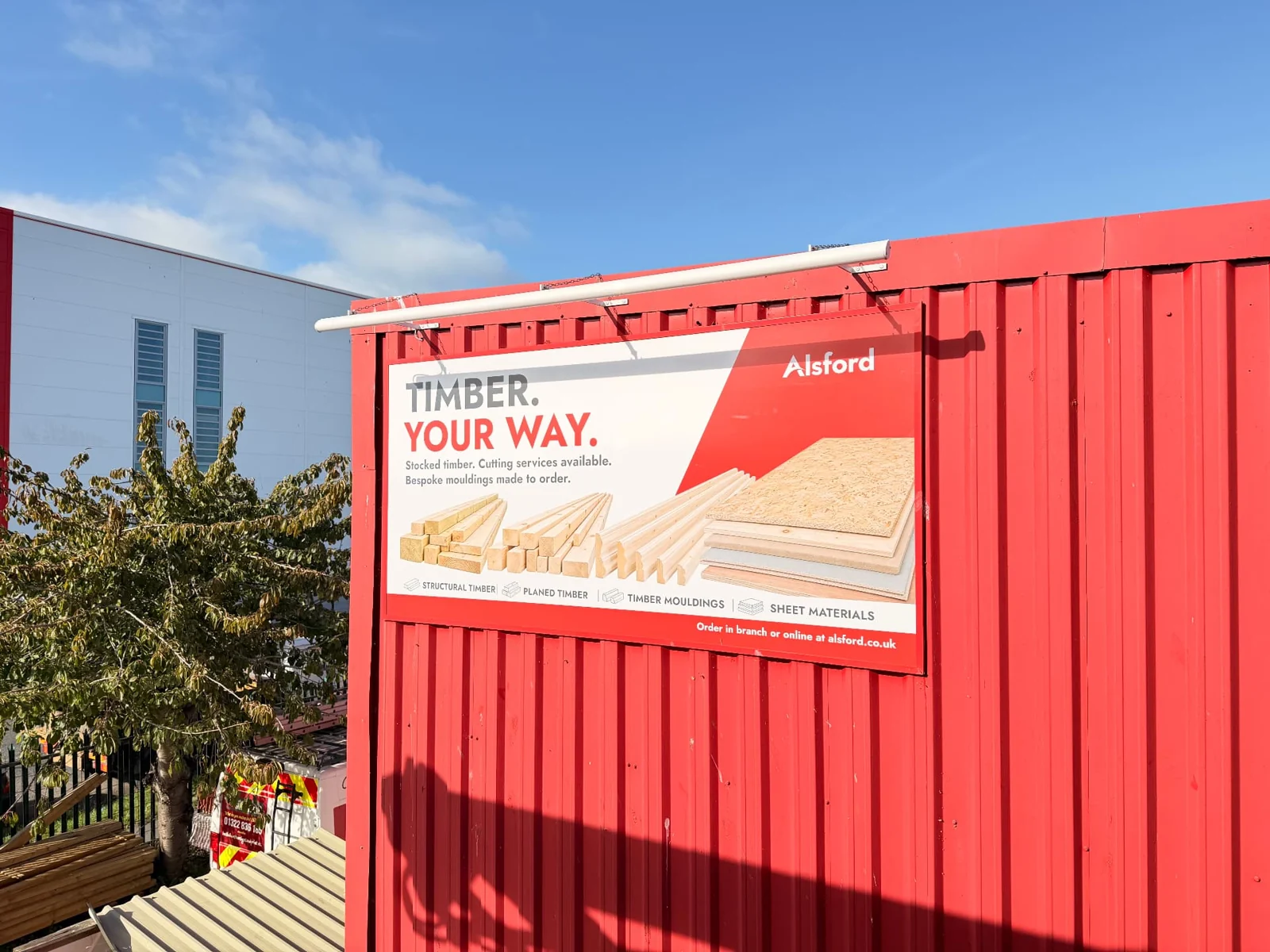 Elevated view of an Alsford campaign billboard on red cladding