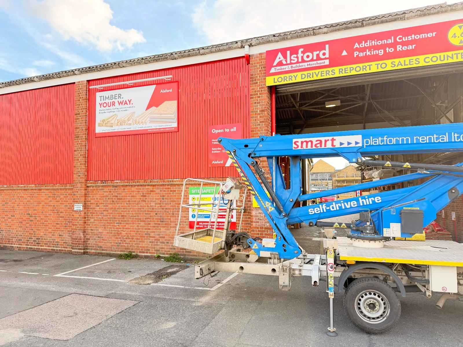 Cherry-picker access equipment beside an Alsford campaign billboard