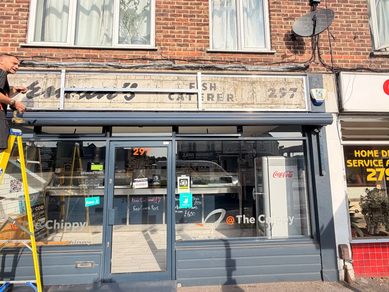 During installation: old fascia removed with supporting framework exposed above The Chippy shopfront